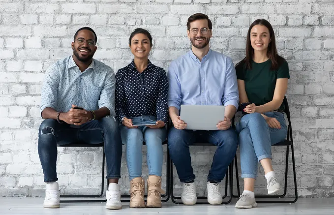 diverse group of job applicants waiting in chairs to be called for an interview